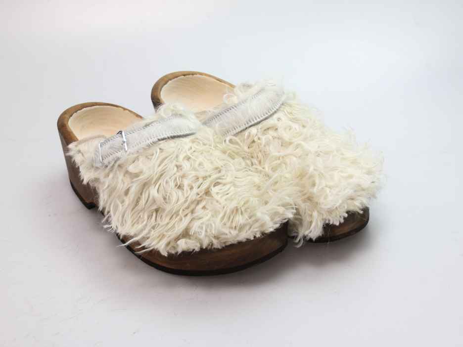 Holzschuh in langem Ziegenfell mit Schaffell