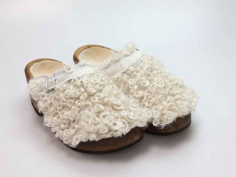 Holzschuh in langem Ziegenfell mit Schaffell